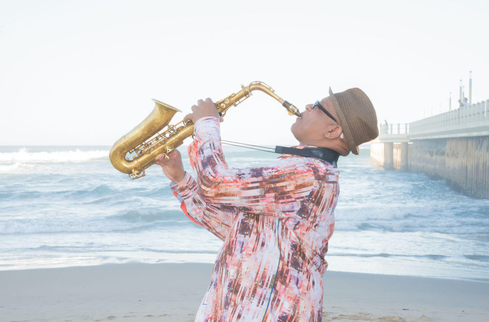 Ernest Dawkins performing saxophone on the beach,